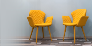 A pair of empty yellow chairs in a blue-gray room
